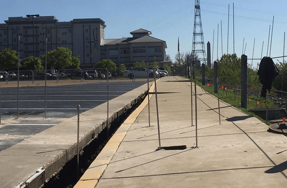 Commercial sidewalk and parking lot in need of conrete lifting service, showcasing maintenance and repair services for public safety.