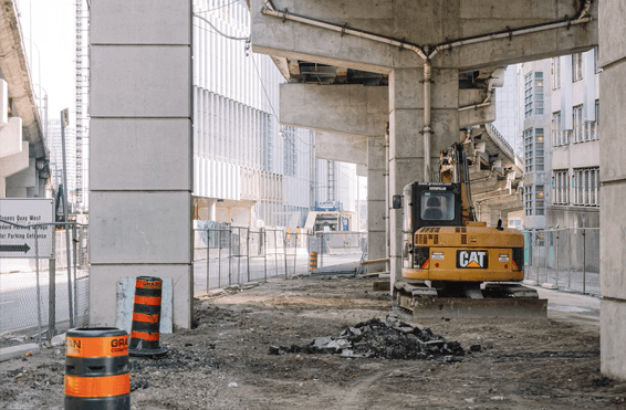 Industrial construction site with large tractor working on working on infrastructure repairs without disrupting operations.